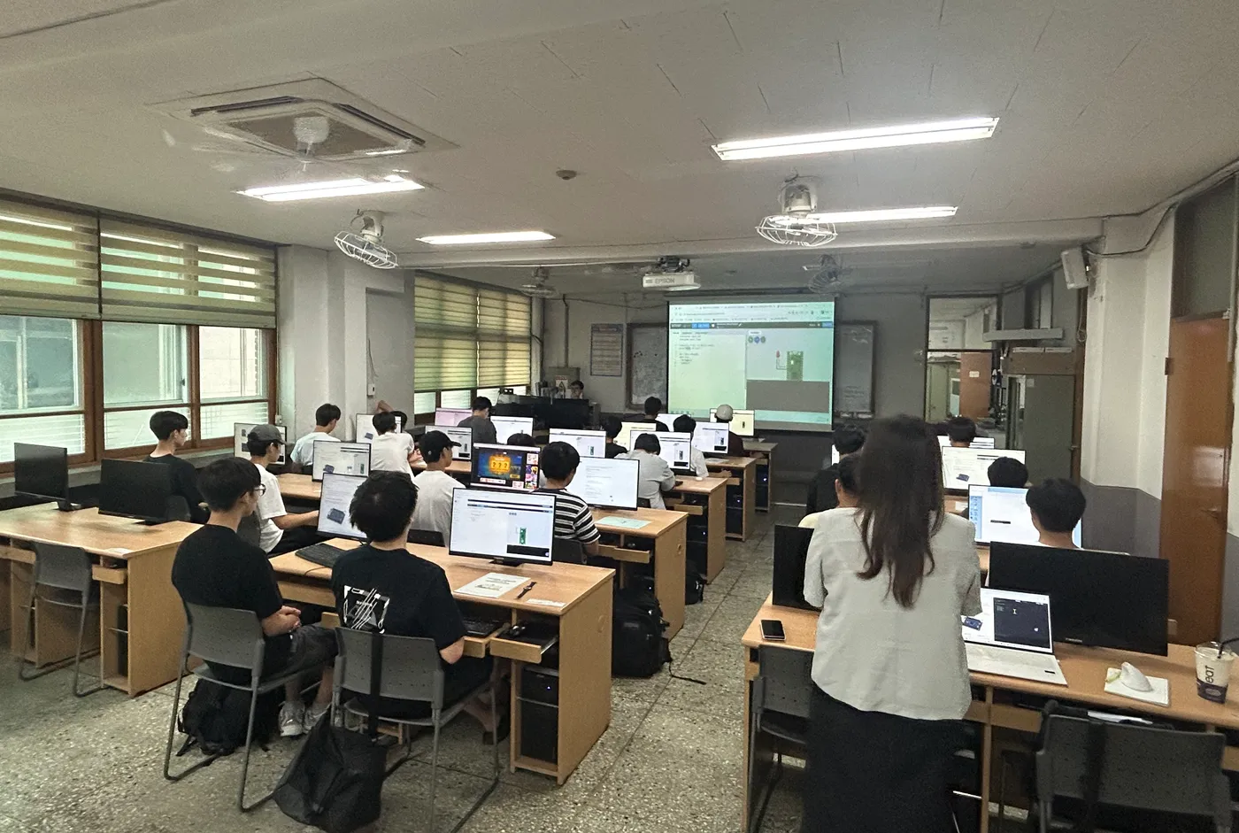 학교 컴퓨터실에서 학생들이 실습 수업을 진행하는 모습
